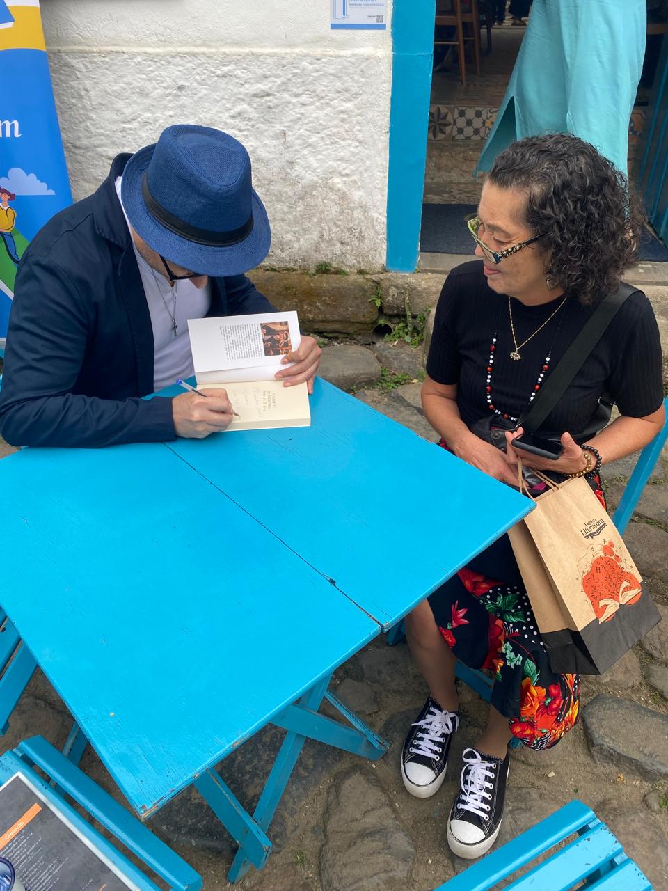 Tommy Bento autografando um livro para uma leitora